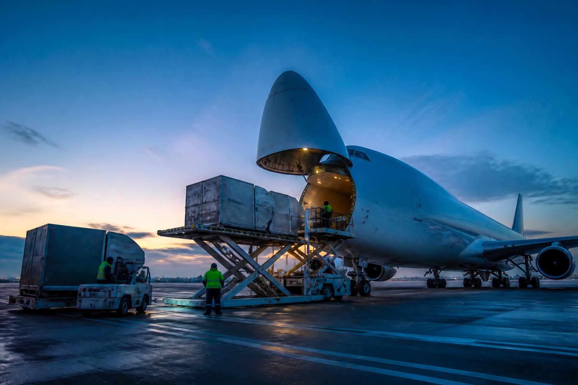 Freighter aircraft being loaded with air cargo at a UK airport at dawn